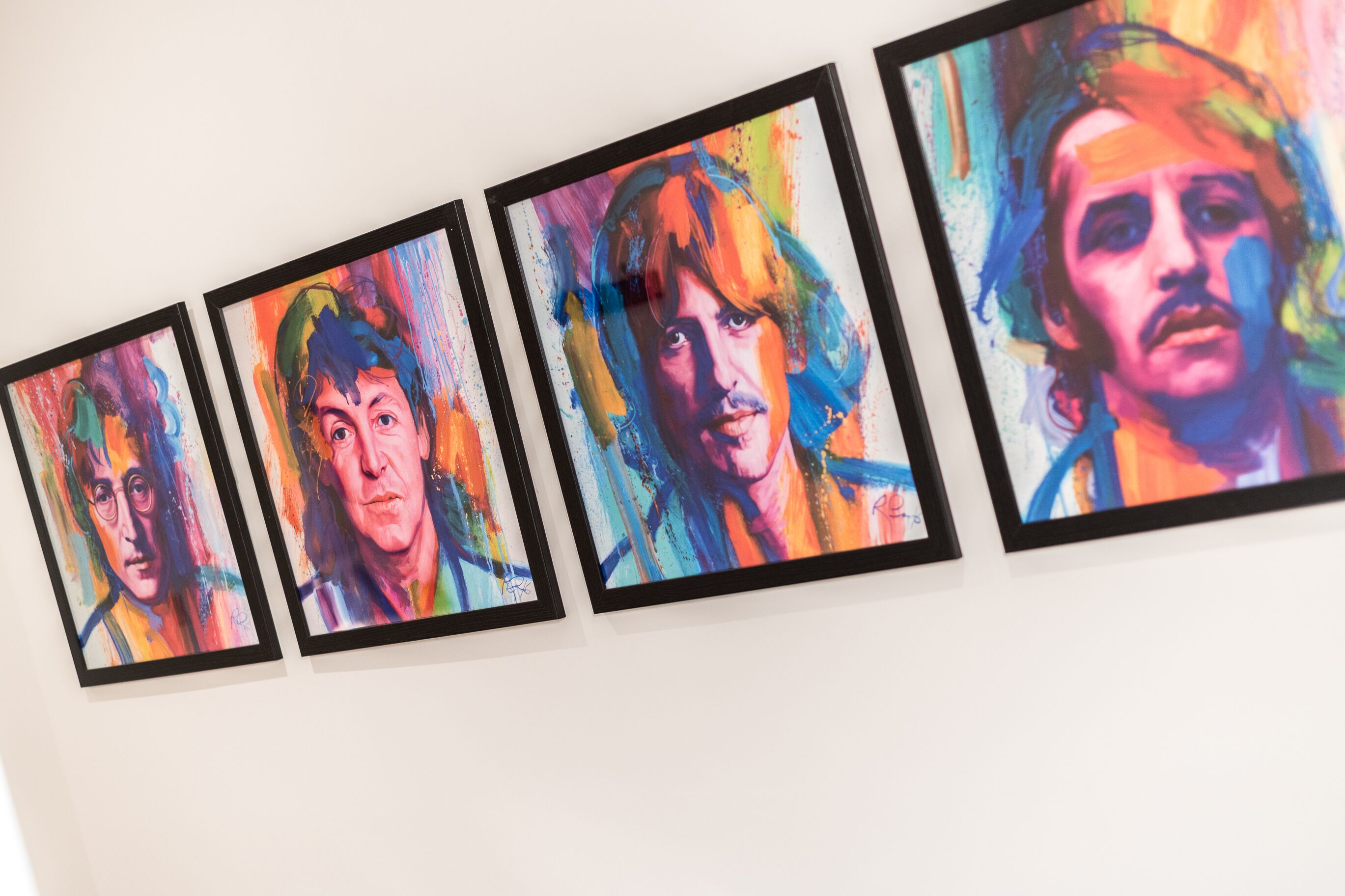 A series of framed artworks on a wall.