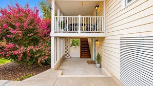 Ein zweistöckiges Gebäude mit einem Balkon, einer Holztreppe und einem Blumentopf.