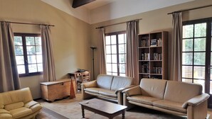 A living room with a sofa, armchair, coffee table, and a bookshelf. - Child-friendly Villa With Pool (Salazac)