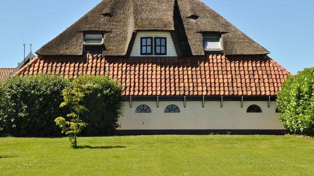 A traditional house with a steeply pitched roof, a chimney, and a tiled roof. - Lovely Holiday Home in Texel near Sea (Oosterend)