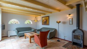 A living room with a fireplace, two sofas, a coffee table, and a floor lamp. - Lovely Holiday Home in Texel near Sea (Oosterend)