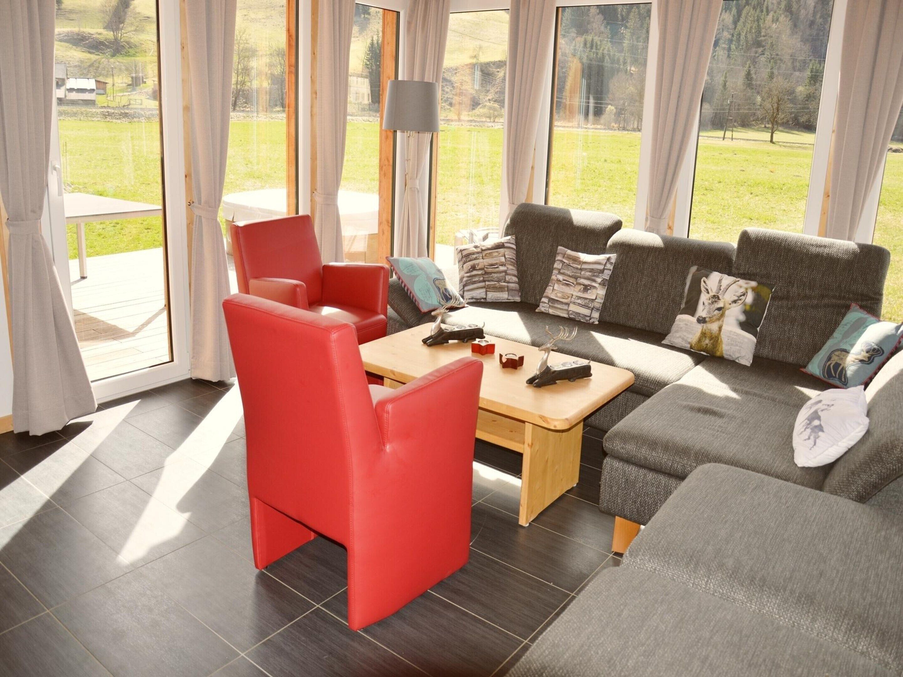 Een moderne woonkamer met een bank, stoelen en een salontafel.