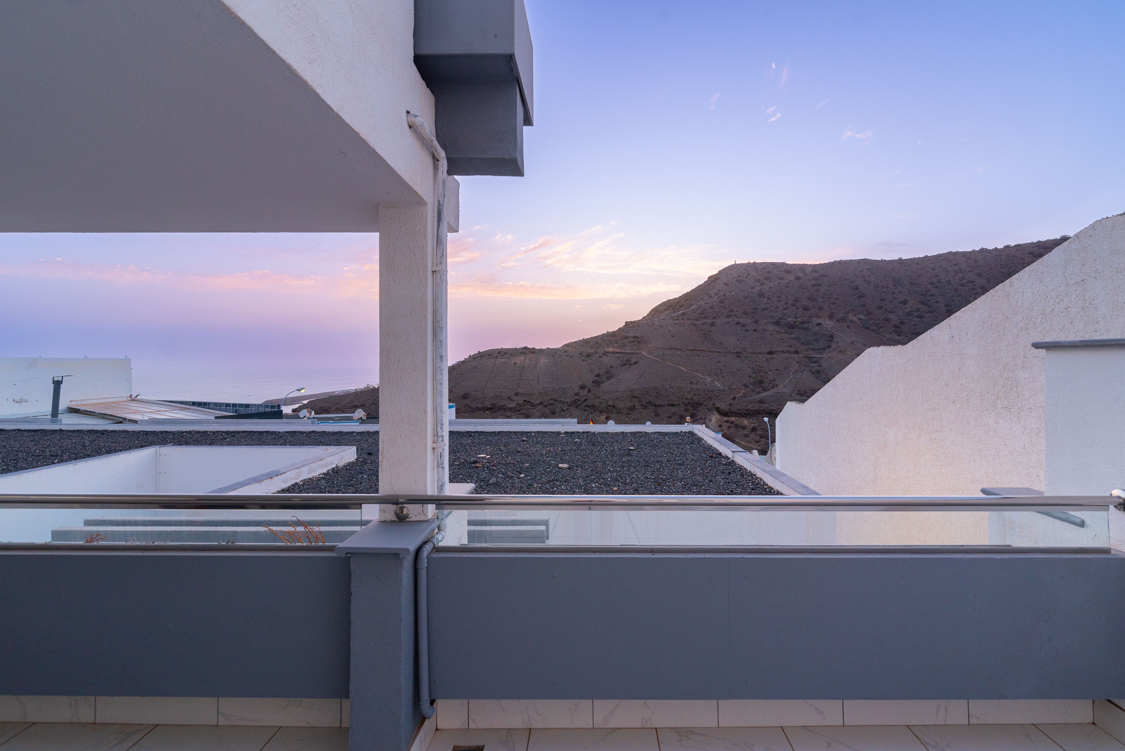 A rooftop terrace with a view of a mountainous landscape.