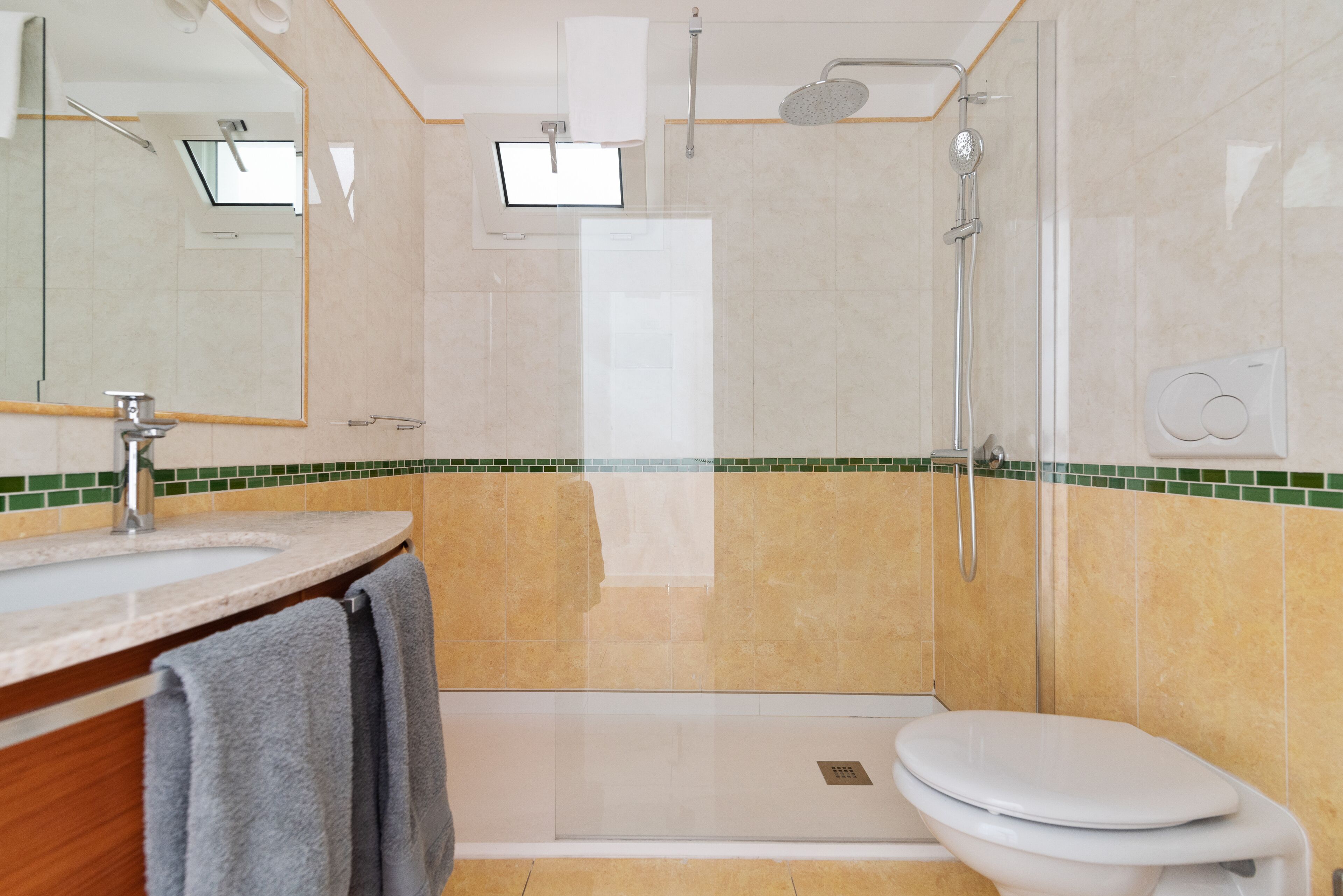 A modern bathroom with a shower, toilet, and sink.