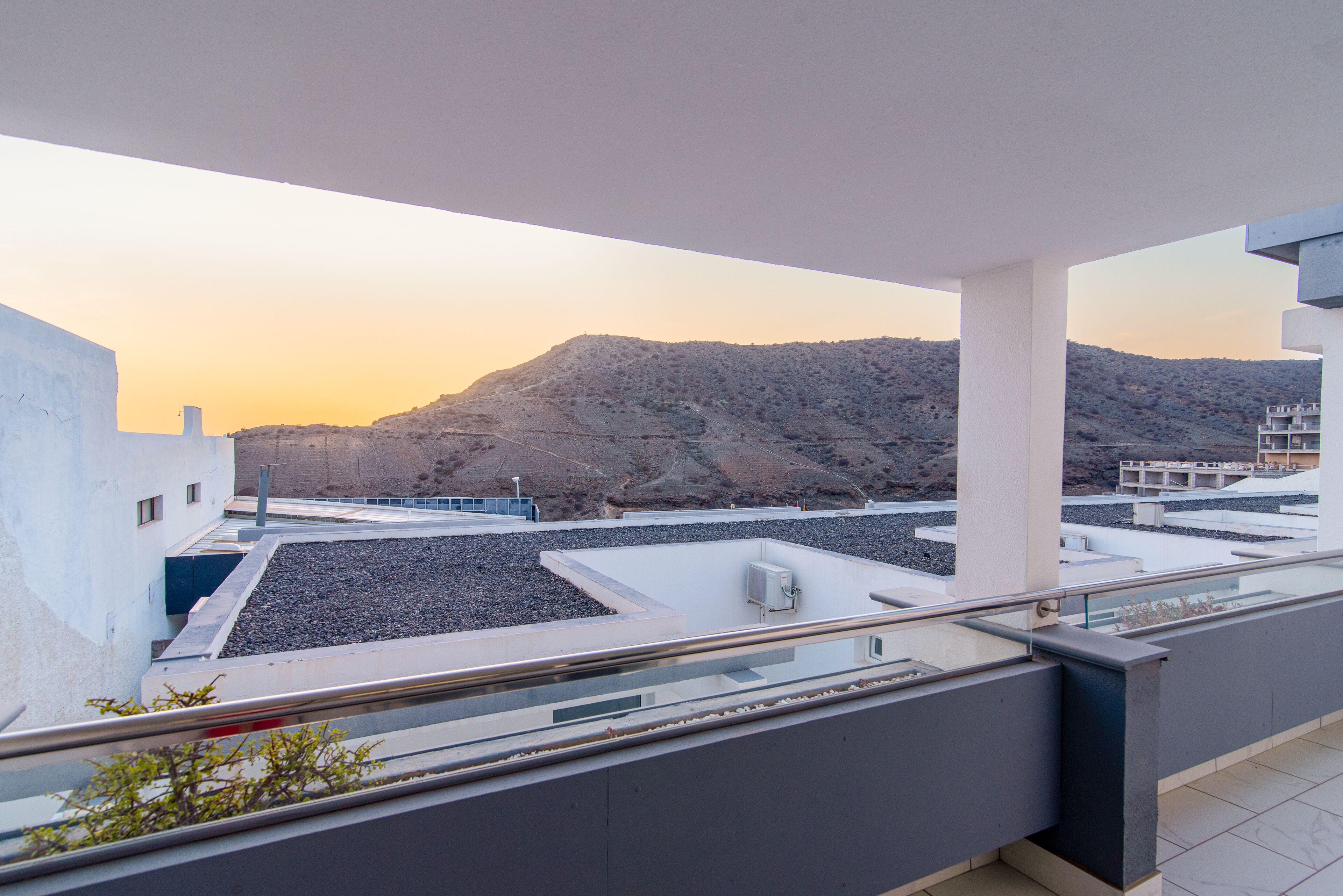 A rooftop terrace with a view of a mountainous landscape.