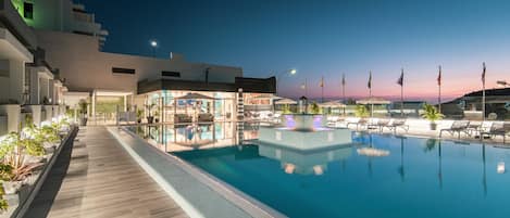 Een buitenzwembad en ligstoelen