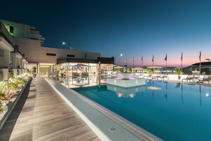 Una piscina al aire libre, sillones reclinables de piscina