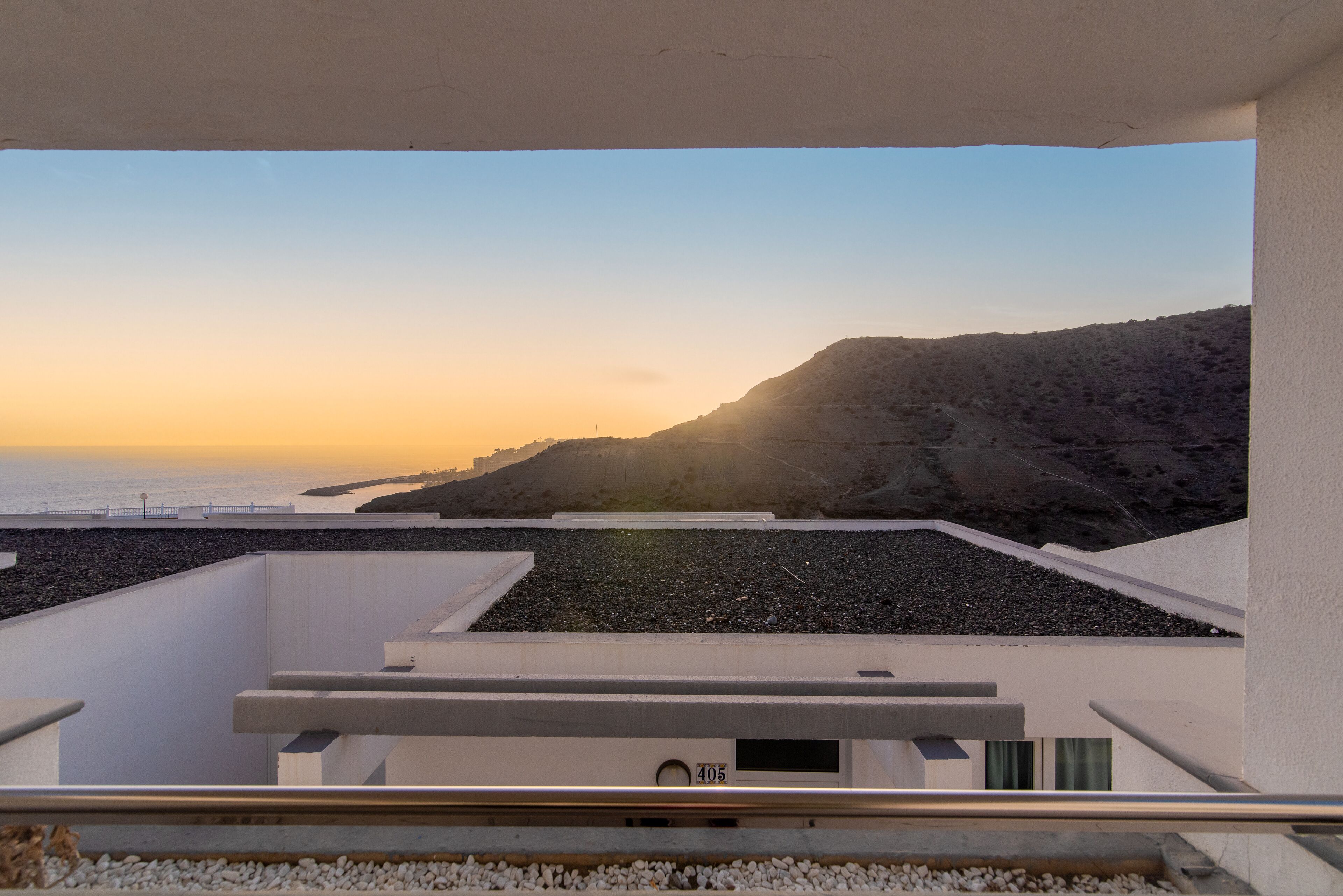 Een modern gebouw met een balkon met uitzicht op een kustlandschap.