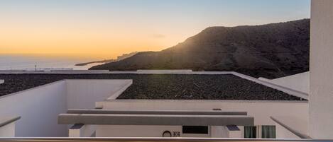 Een modern gebouw met een balkon met uitzicht op een kustlandschap.