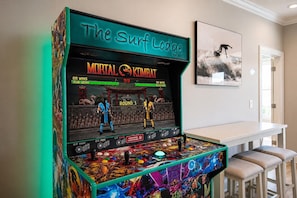 Una máquina de videojuegos de Mortal Kombat con un letrero de neón que dice 'The Surf Lodge'.