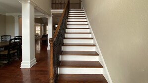 A staircase with wooden steps and a handrail, leading to an upper level.