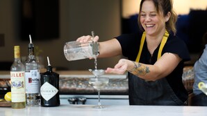 Un barista versa un drink in un bicchiere.