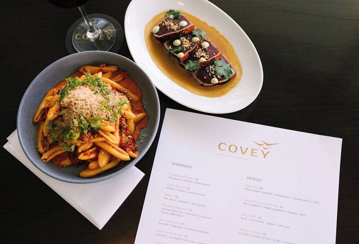 A menu with a pasta dish and a steak dish, both garnished with herbs.