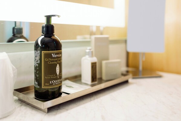 Une bouteille de savon liquide à la verveine, posée sur le comptoir d’une salle de bain.
