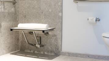 A bathroom with a shower, a toilet, and a towel rack.