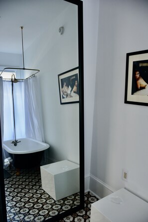 A bathroom with a bathtub, a shower curtain, a toilet, and a sink. - The Hugh Boutique B&B (Cape May)