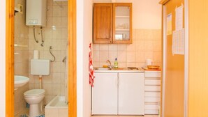A bathroom with a toilet, sink, and shower.