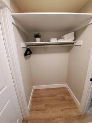 A small, enclosed closet with a wooden floor, white walls, and a white door. - Modern Condo only Minutes from Deadwood & Sturgis! (Lead)
