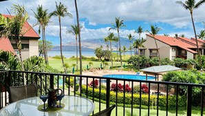 Ein Hotel mit Pool, Palmen und Meerblick.