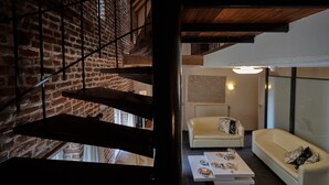 Een trap met een bakstenen muur, een witte bank en een tafel met gebak.