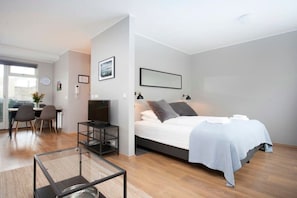 Relax in a spacious room with a large bed, glass coffee table, and flat-screen TV.