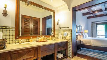 A bathroom with a double sink, wooden vanity, and a large mirror.