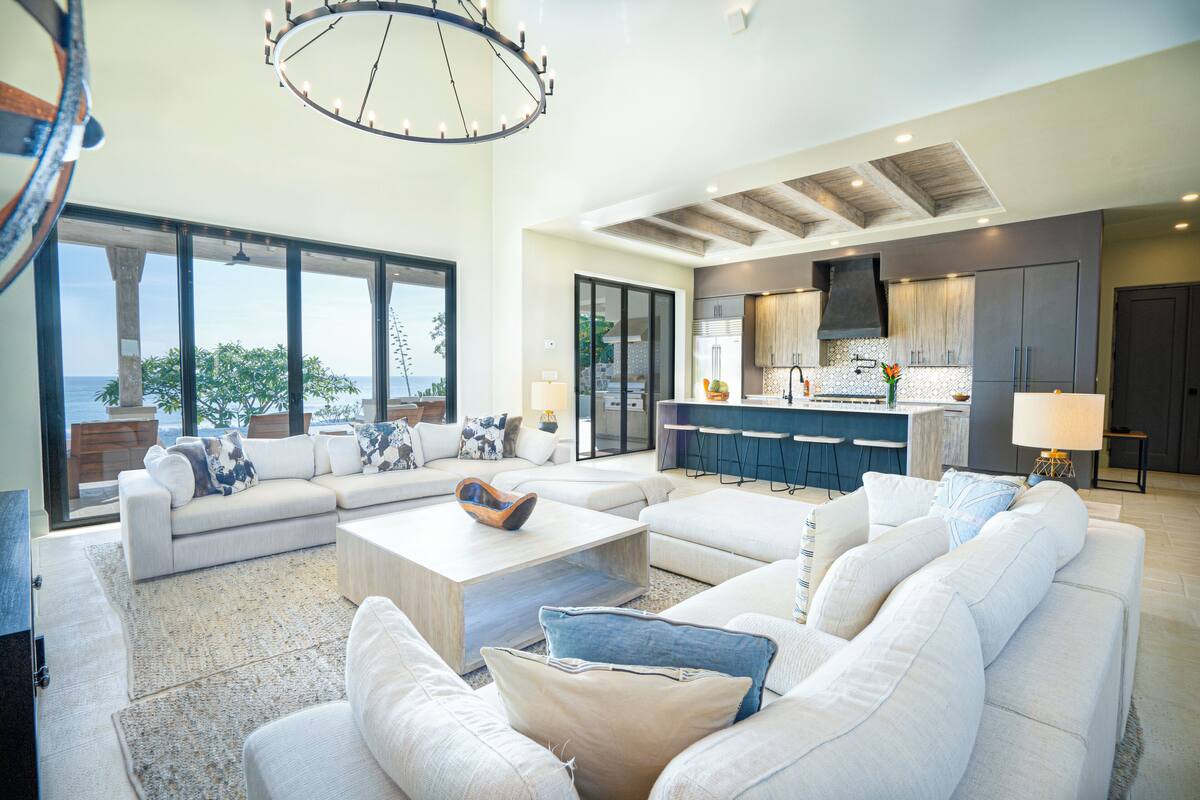 A spacious living area with a large window, a modern kitchen, and a seating area with a coffee table.