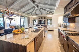 Una cocina moderna con una isla grande, armarios de madera y una estufa empotrada.