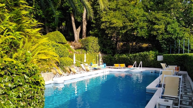 A swimming pool with lounge chairs and a tiled deck. - Eurotel 312 (Rapallo)