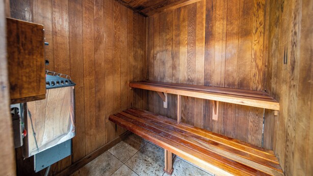 A wooden sauna with benches and a sauna heater. - Luana Kai Resort D103 (Kihei)