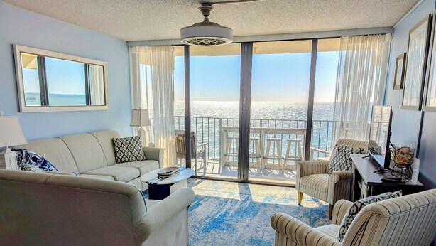 A living room with a sofa, armchairs, a coffee table, and a view of the sea through large windows. - Stunning OCEAN FRONT Large 2 bedroom SUITE with breathtaking views (Murrells Inlet)