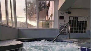 A hot tub area with a view of palm trees and a building outside. - Stunning OCEAN FRONT Large 2 bedroom SUITE with breathtaking views (Murrells Inlet)