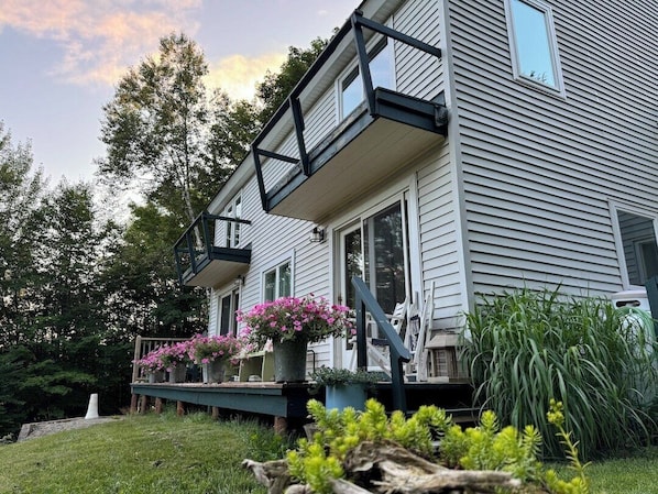 A house with a porch, potted plants, and a wooden deck.