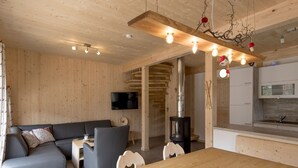 A modern living space with a wooden interior, a dining area, and a kitchen. - Nice Chalet With Whirlpool (Sankt Georgen am Kreischberg)