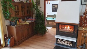 A cozy living room with a fireplace, wooden cabinets, and a dining area.