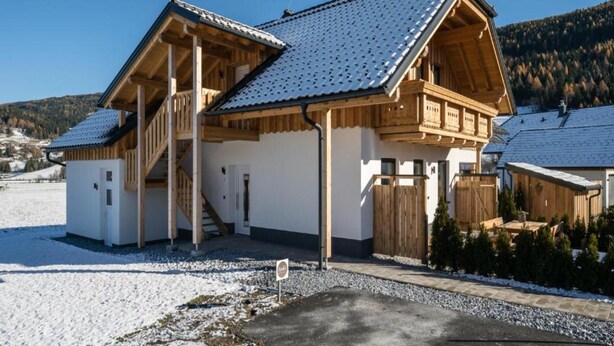 A wooden chalet with a sloped roof, a covered porch, and a staircase leading to an upper level. - Huge Apartment in Sankt Margarethen im Lungau near Ski Lift (Sankt Michael im Lungau)