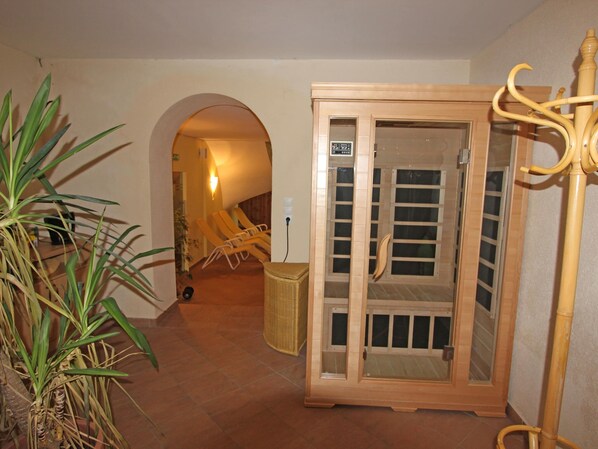 Una habitación con sauna de madera, una cesta de mimbre y una planta.