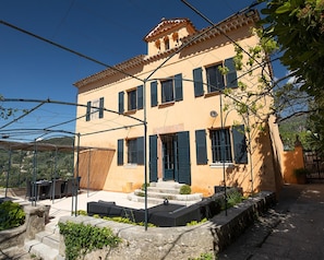 A two-story building with a balcony, a staircase, and a garden area. - 18thc Perfumer's Home, Heated Pool & View (Grasse)