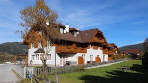 A traditional chalet-style building with a wooden facade, multiple balconies, and a white exterior. - Vogue Apartment in Sankt Margarethen im Lungau near Ski Lift (Sankt Margarethen im Lungau)