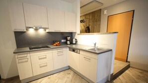 A modern kitchen with white cabinetry, a stainless steel sink, and a coffee maker. - Vogue Apartment in Sankt Margarethen im Lungau near Ski Lift (Sankt Margarethen im Lungau)