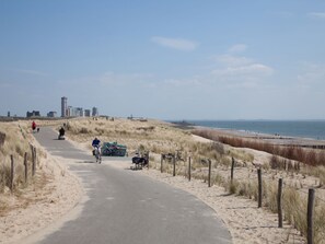 A coastal path with bicycles and pedestrians, leading to a beach. - Apartment in Flushing Near Vlissing Beach (Vlissingen)