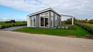 A modern house with large glass windows and a sloped roof.