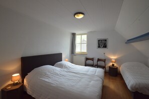 A bedroom with two beds, a window, a radiator, and a framed picture on the wall. - Farmhouse in Elsendorp Near Forest Trails (Elsendorp)