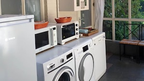 A laundry area with a Bosch refrigerator, two microwaves, and a washing machine. - Holiday Home in Soerendonk With Garden (Soerendonk)