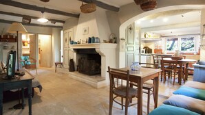 A cozy living room with a fireplace, wooden furniture, and a dining area. - Cottage in Oppede With Pool and Garden (Oppede)