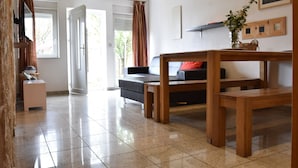 A spacious living area with a sofa, wooden coffee table, and a dining table. - Wheelchair-friendly Escape (Varsberg)