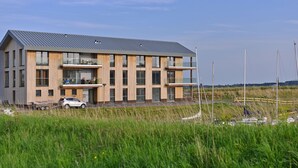 A modern multi-story building with a flat roof, large windows, and balconies. - Holiday Home in Kamperland (Kamperland)