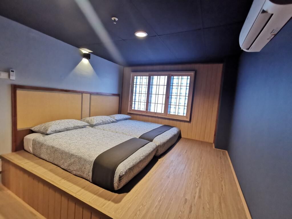 Une chambre à coucher avec un lit, une fenêtre et un appareil de climatisation.