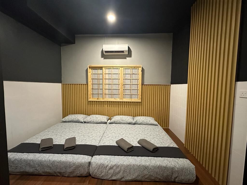Una habitación con cama, ventana y aire acondicionado de pared.