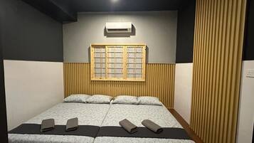 Una habitación con cama, ventana y aire acondicionado de pared.